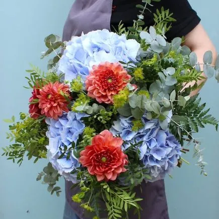 Ramo de hortensias azules y dahlias salmones de lado